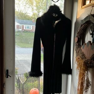 Long sleeved, full length sweater with hood and feathers on the edges.